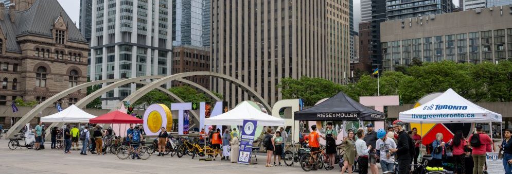 Nathan Philips Square facing south with bicycles and tents in the foreground and tall buildings to the south of Queen street in the rear.
