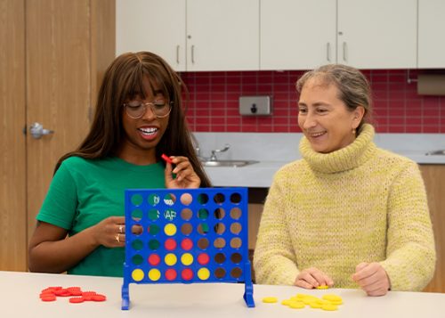 A City staff member is playing with an older adult within the City's facility.