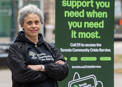 A person standing next to a pull up posted that reads Support You Need When you Need It Most.