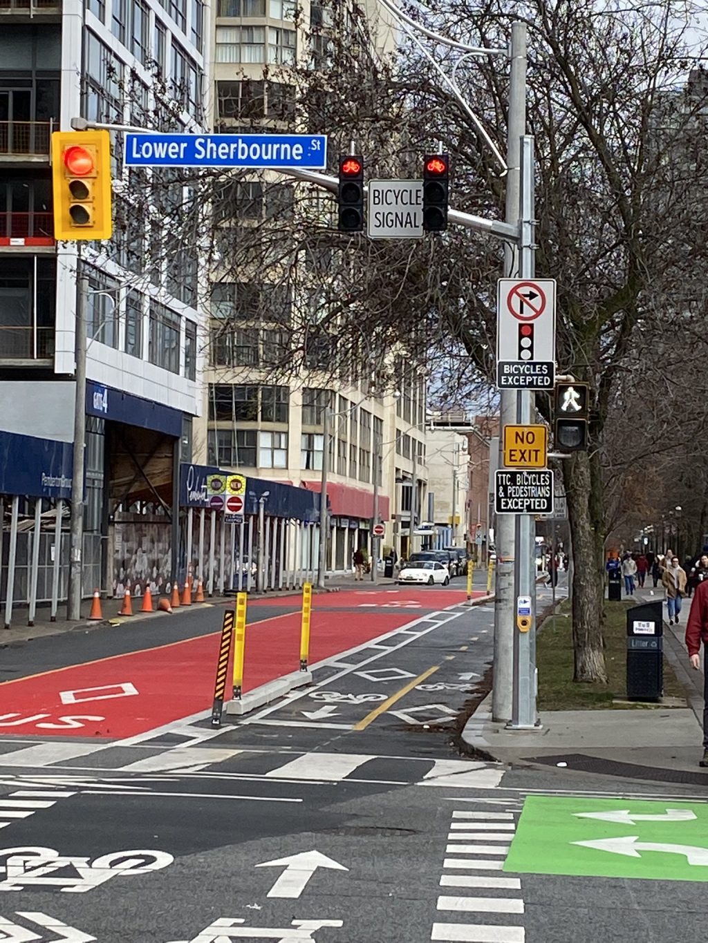 Two-way bikeway at an intersection, featuring bicycle signals, turn restriction signage and bicycle boxes.