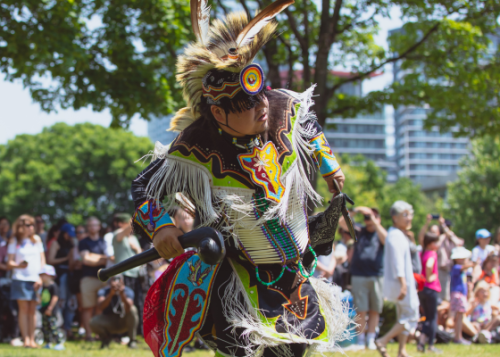 Close up of a dancer outside and crowd watches