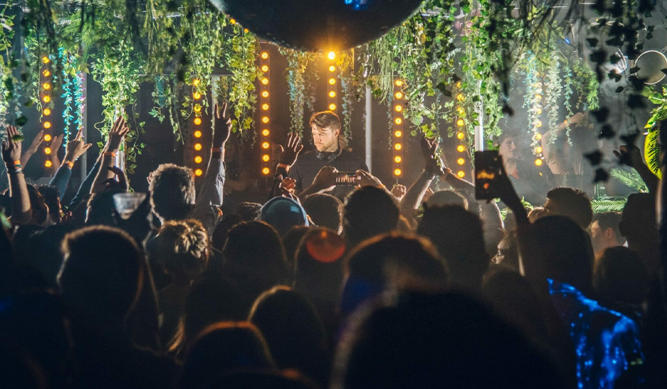 Man performs on a stage with crowd in foreground